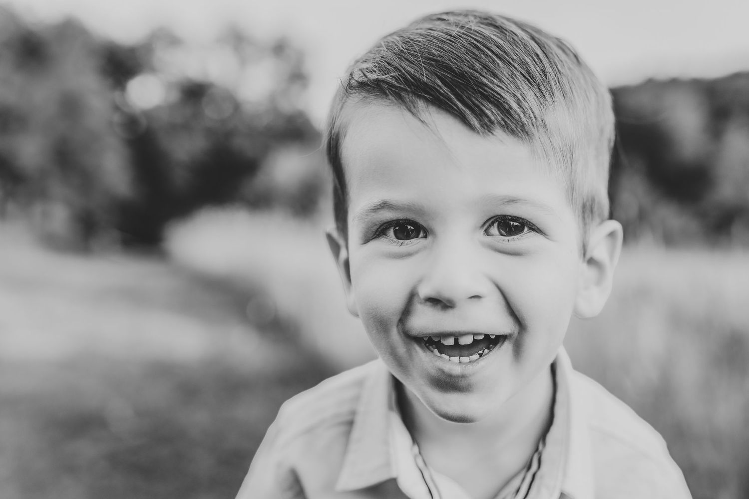 Close up black and white portrait of young child with bright smile.