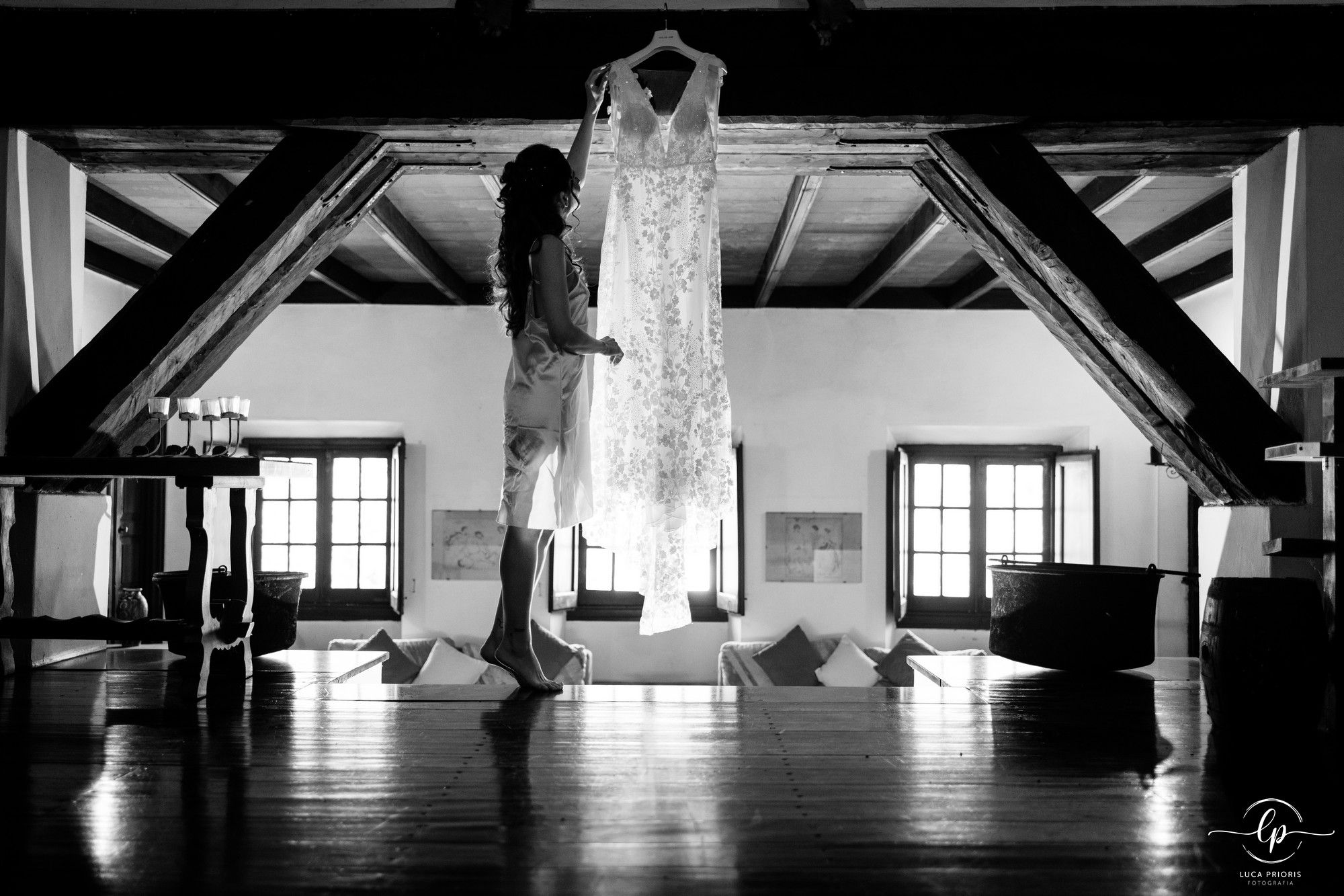 la sposa guarda l'abito appeso