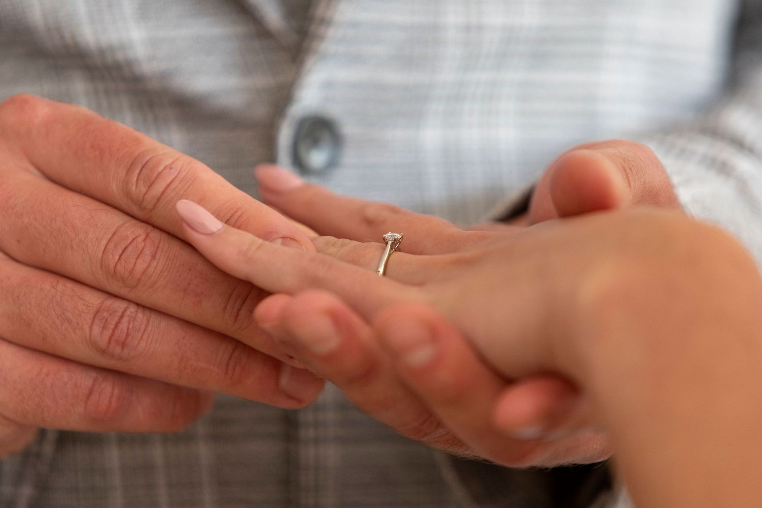 Groom placing ring on Bride's finger at wedding ceremony in Bristol