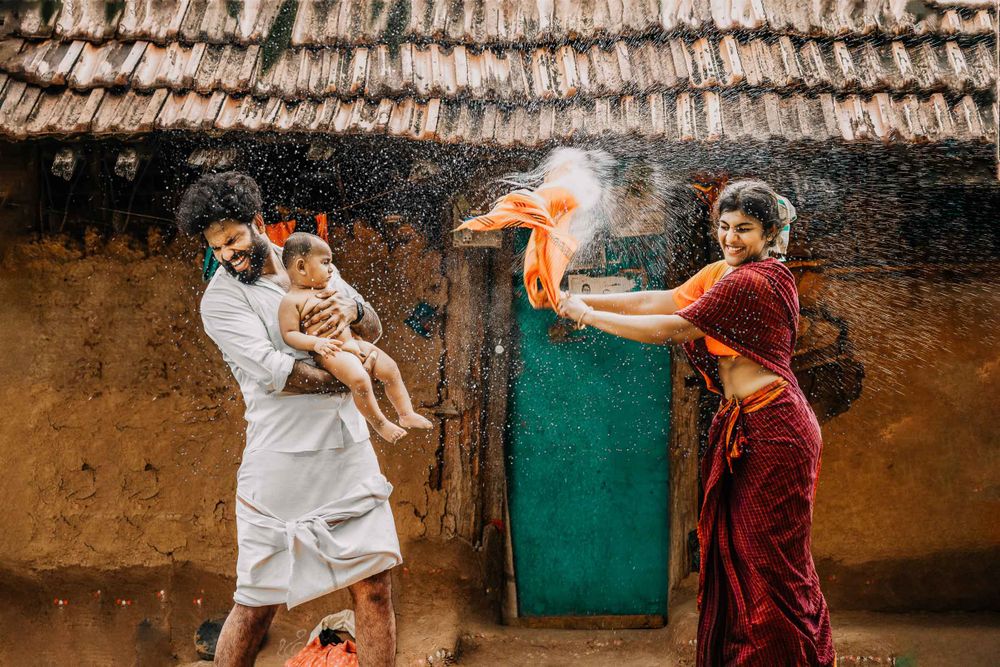 Creative village theme family portrait of a couple with their one month old baby boy captured by top baby photographer
