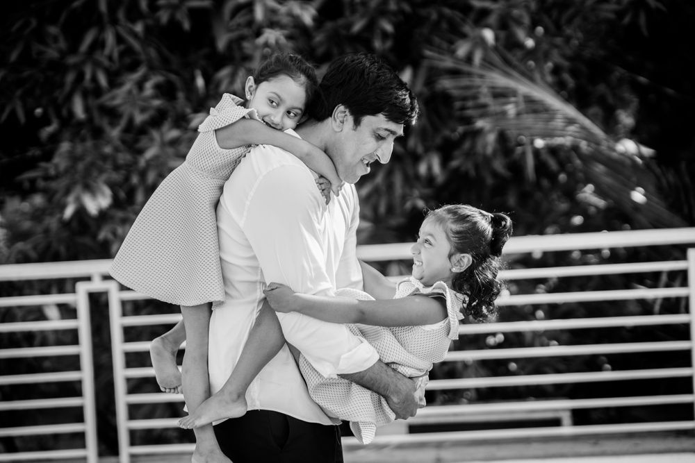 Little vows baby photogrpaher captured a beautiful family portrait of father holding his twin baby girls around him