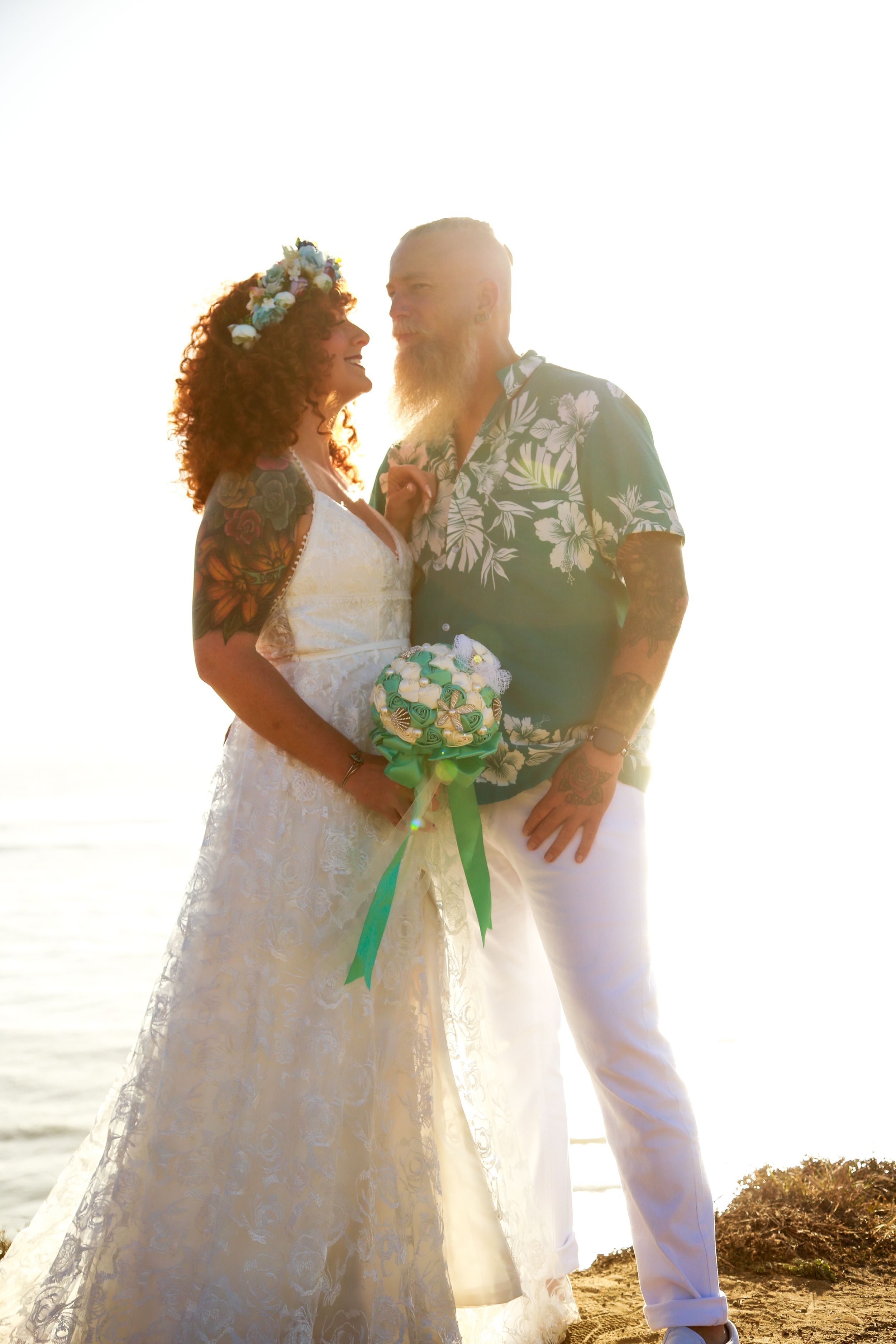 Newlyweds share intimate moments during their sunset beach wedding ceremony.