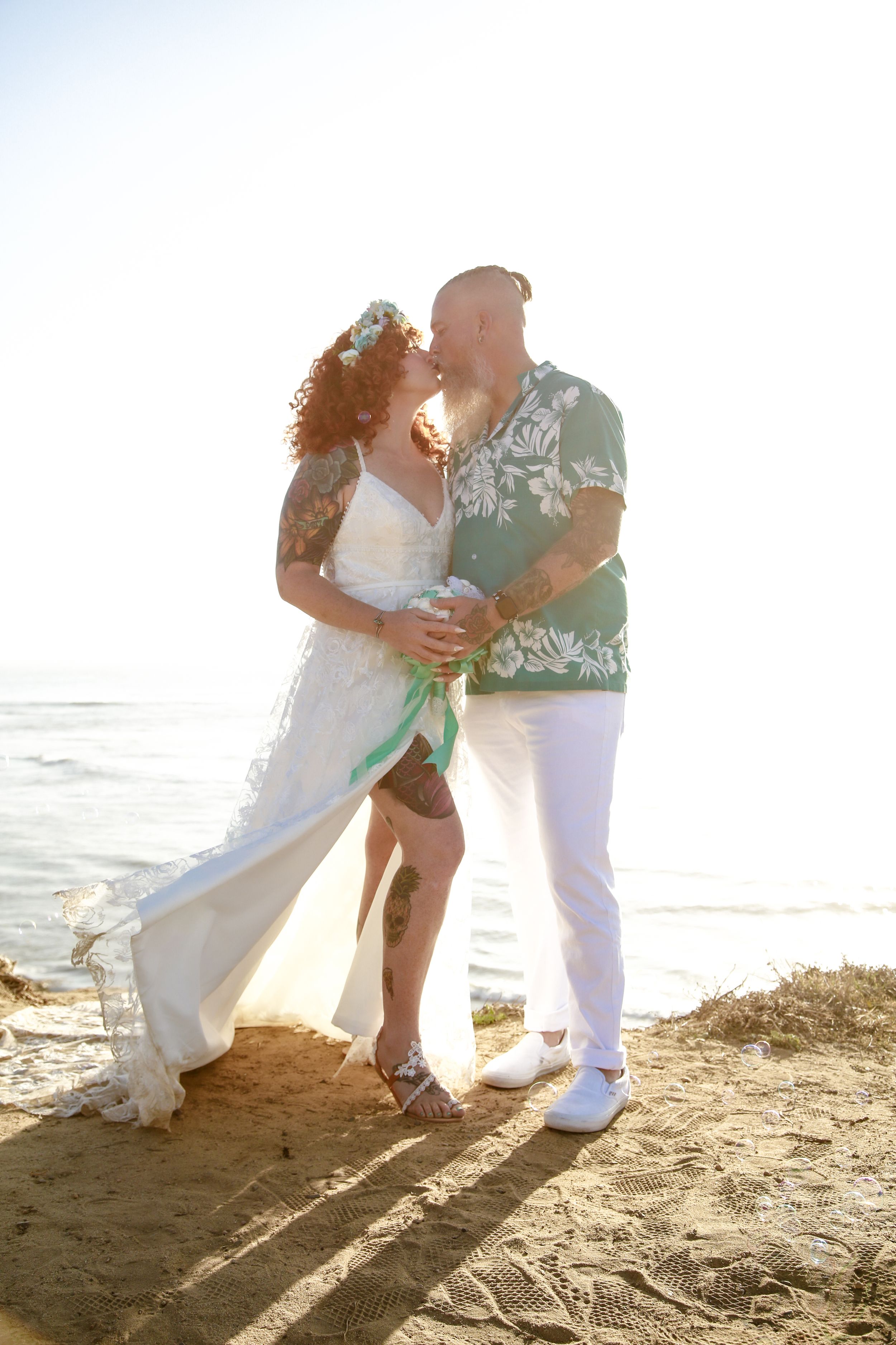 A romantic beach wedding photoshoot with golden sunlight streaming through.