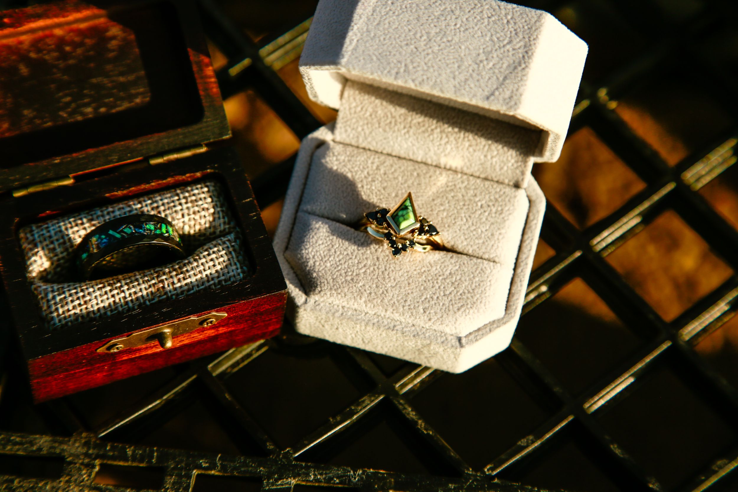 Wedding rings nestled in a white velvet box with vintage decorative elements.