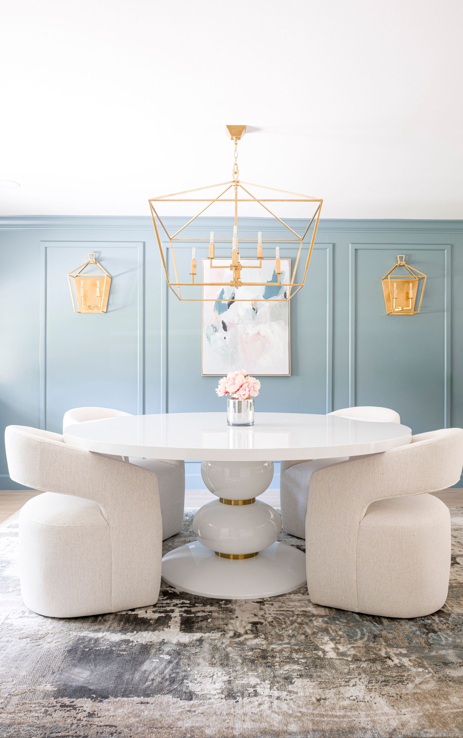Elegant dining room with white round table, curved chairs and gold geometric chandelier. Interior Design, NJ Photo