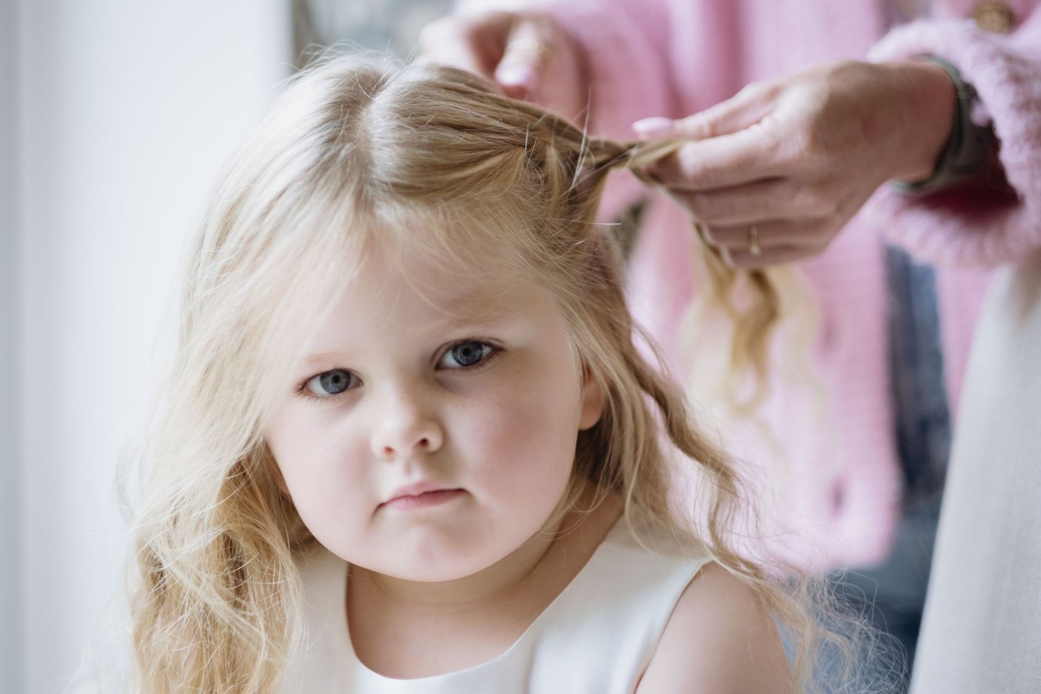 Young bridesmaid has her hair done for a wedding