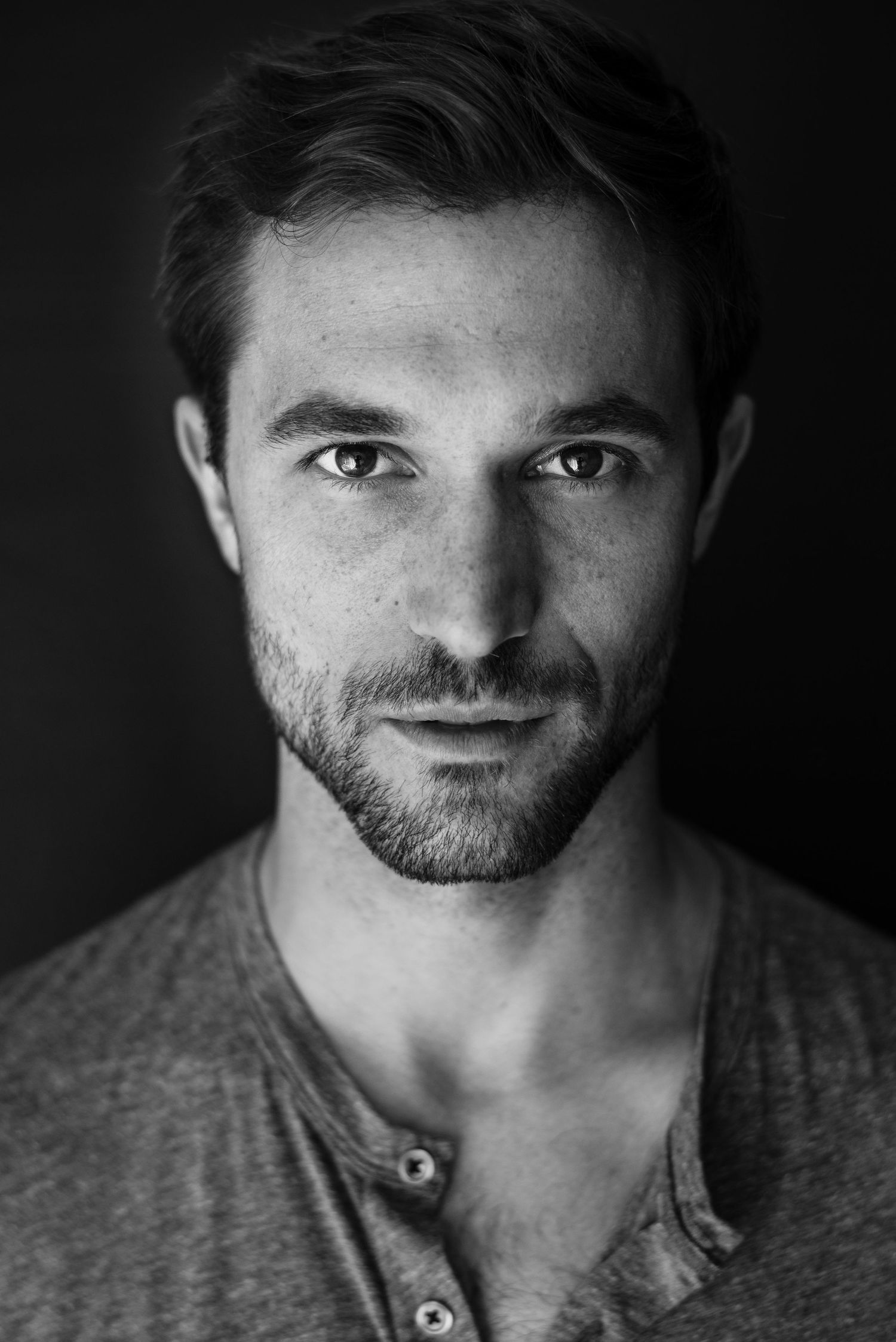 Black and white close-up portrait of person in henley shirt.