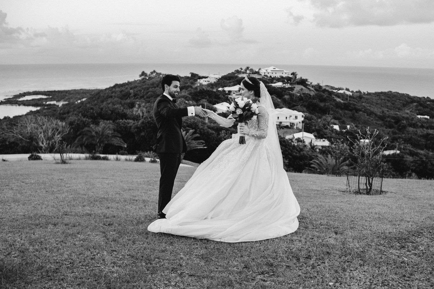 Panoramic view of a coastal wedding venue with rolling hills and ocean in the background.