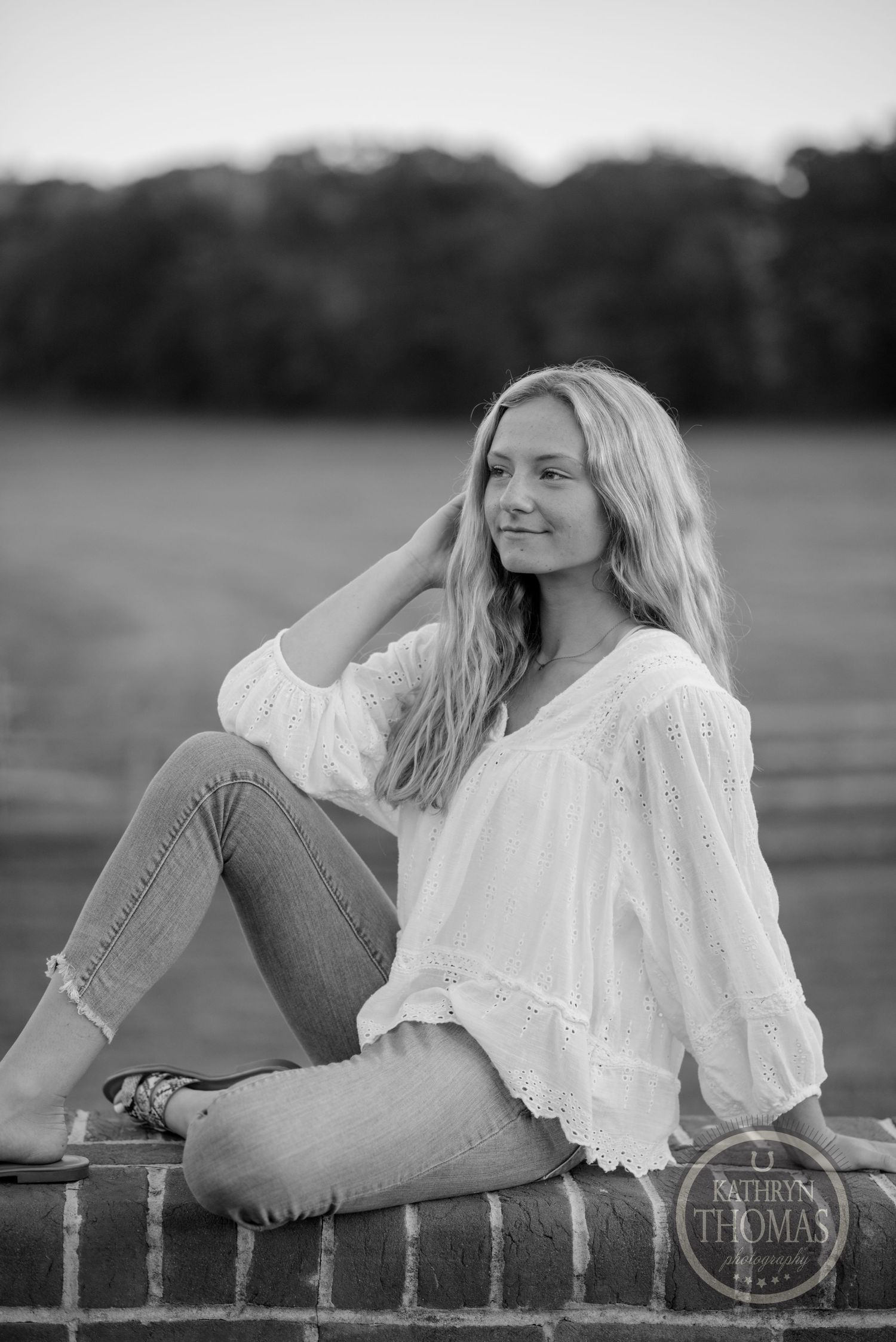 Black and white portrait on brick wall showing casual summer style and natural lighting.