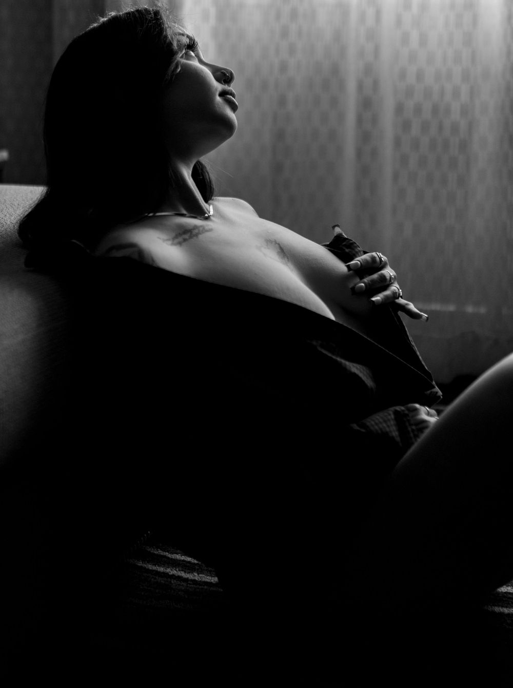 A woman in a men's shirt poses sitting on the floor for the best boudoir photographer in the Phoenix Arizona area