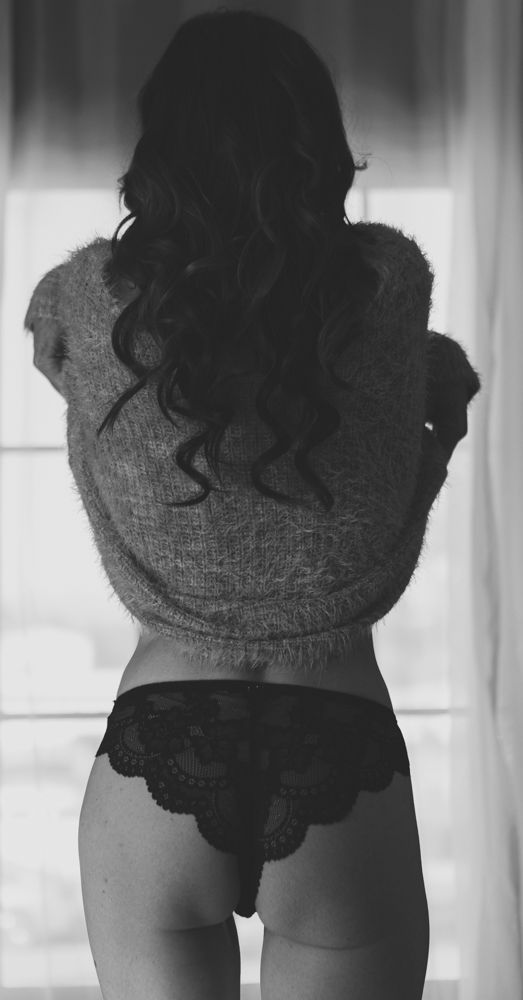A woman in black lingerie poses standing removing shirt for the best boudoir photographer in the Phoenix Arizona area