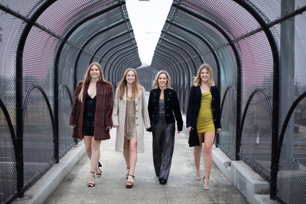 Group walking through modern tunnel with curved black architectural features.