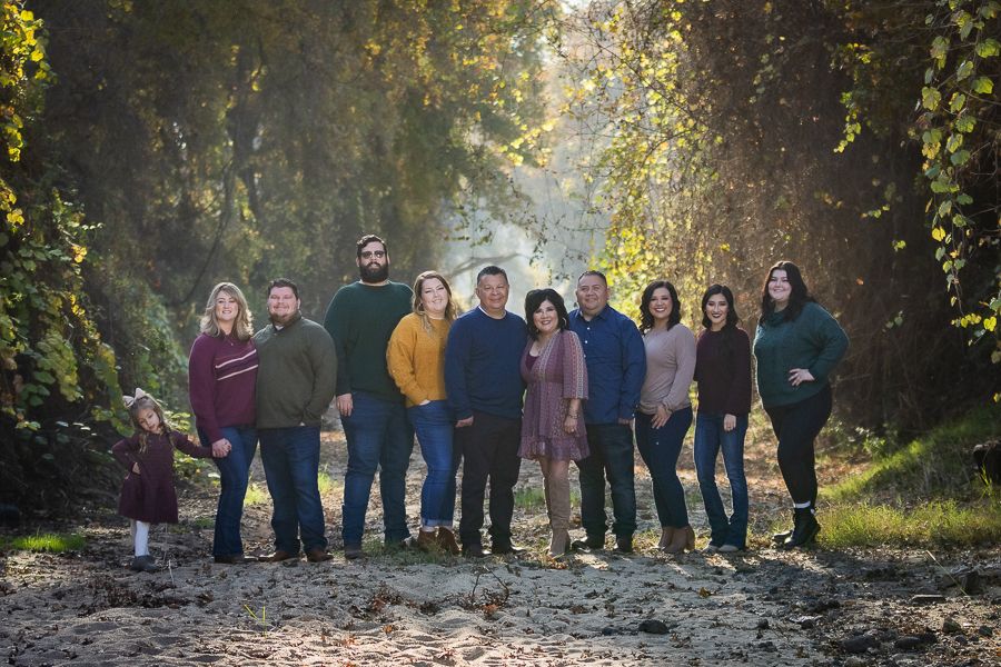 Extended family portrait session in a natural wooded setting with autumn colors.