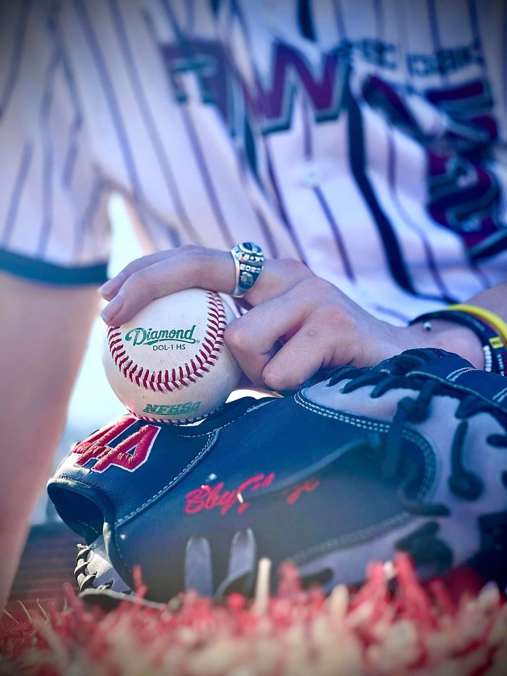 Baseball-themed engagement photo with ring and signed baseball.