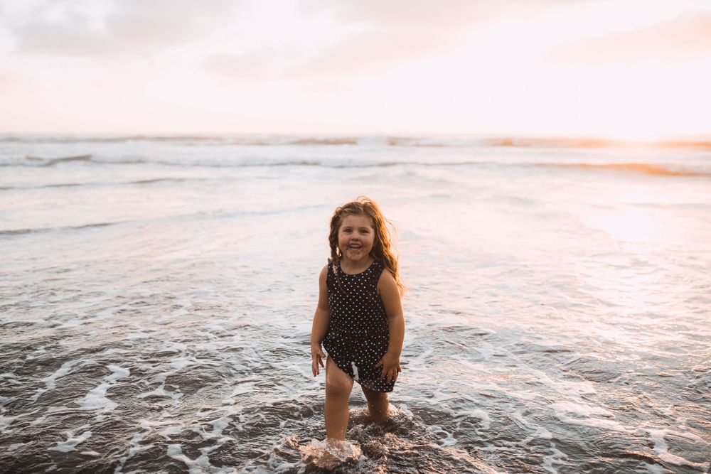 A joyful moment captured of playing in the ocean waves during sunset.