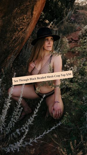 Product photography of beaded mesh top in natural desert setting with red rock formations.