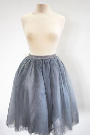 A light gray tulle midi skirt displayed on a cream-colored dress form mannequin against a white background.
