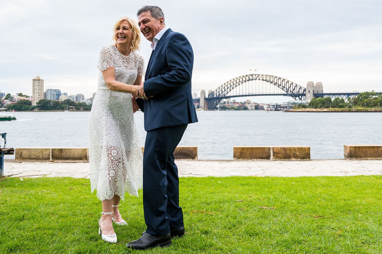 Couple in formal wear dancing with Sydney Harbour Bridge in background.