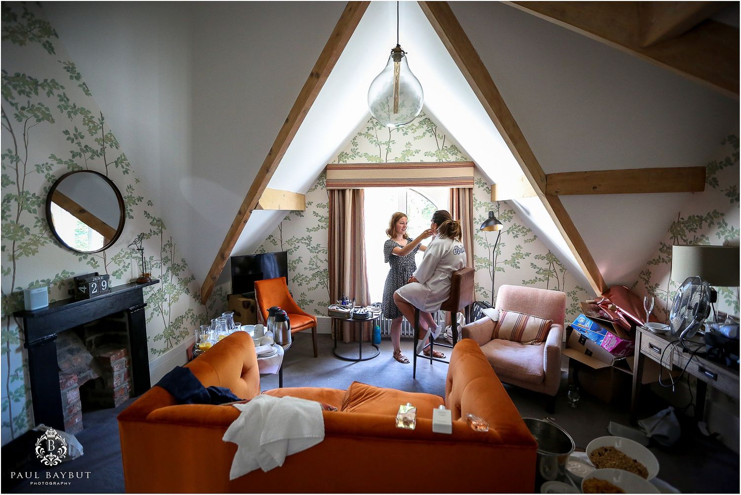 Make up artist prepares a seated bride in the bedroom of her Didsbury house wedding