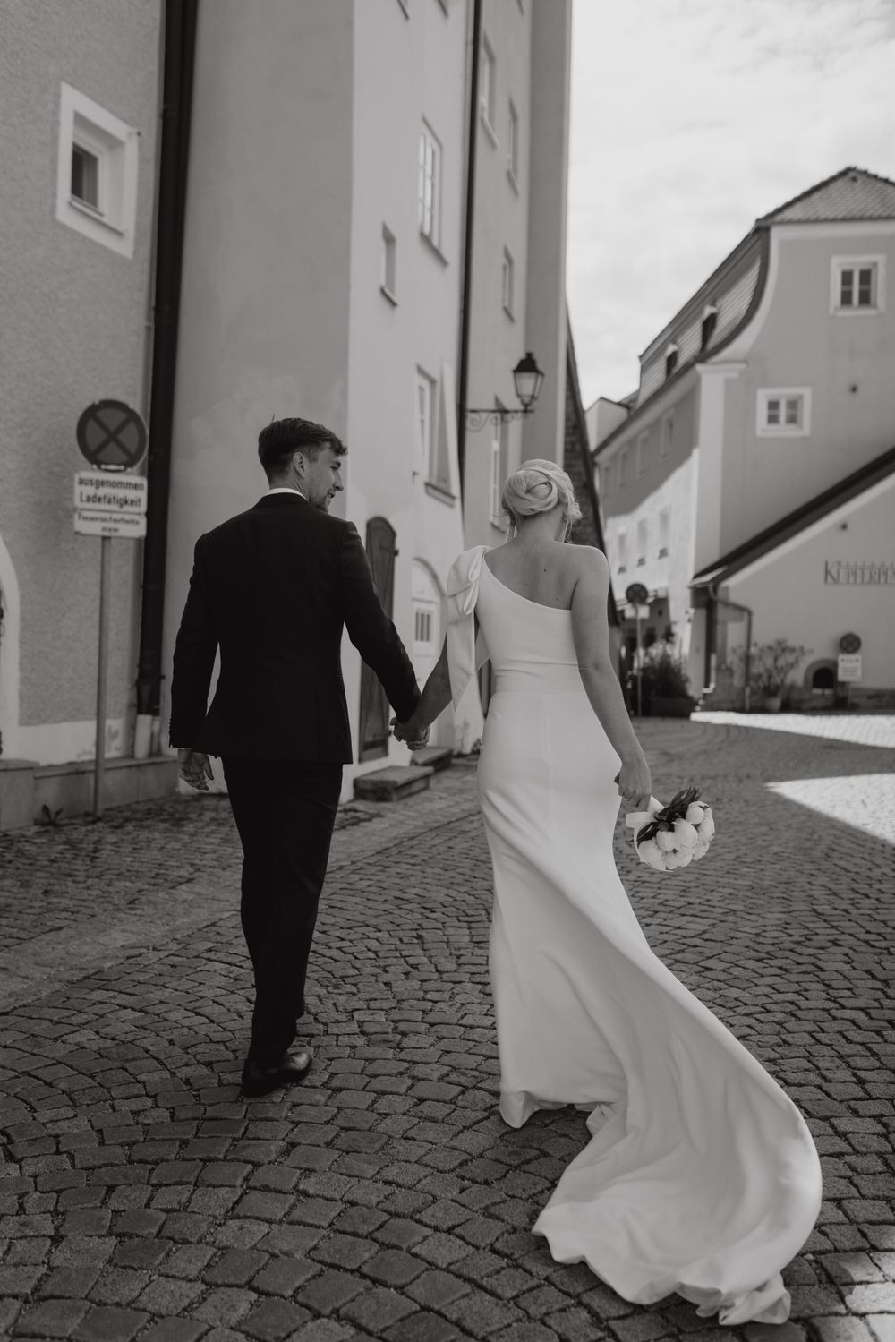Brautpaar geht eine Straße entlang
