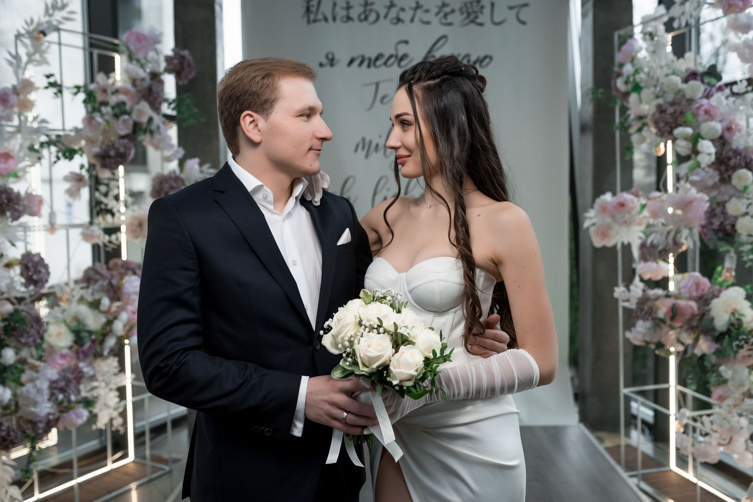 Romantic moment captured during a wedding ceremony with floral decorations.