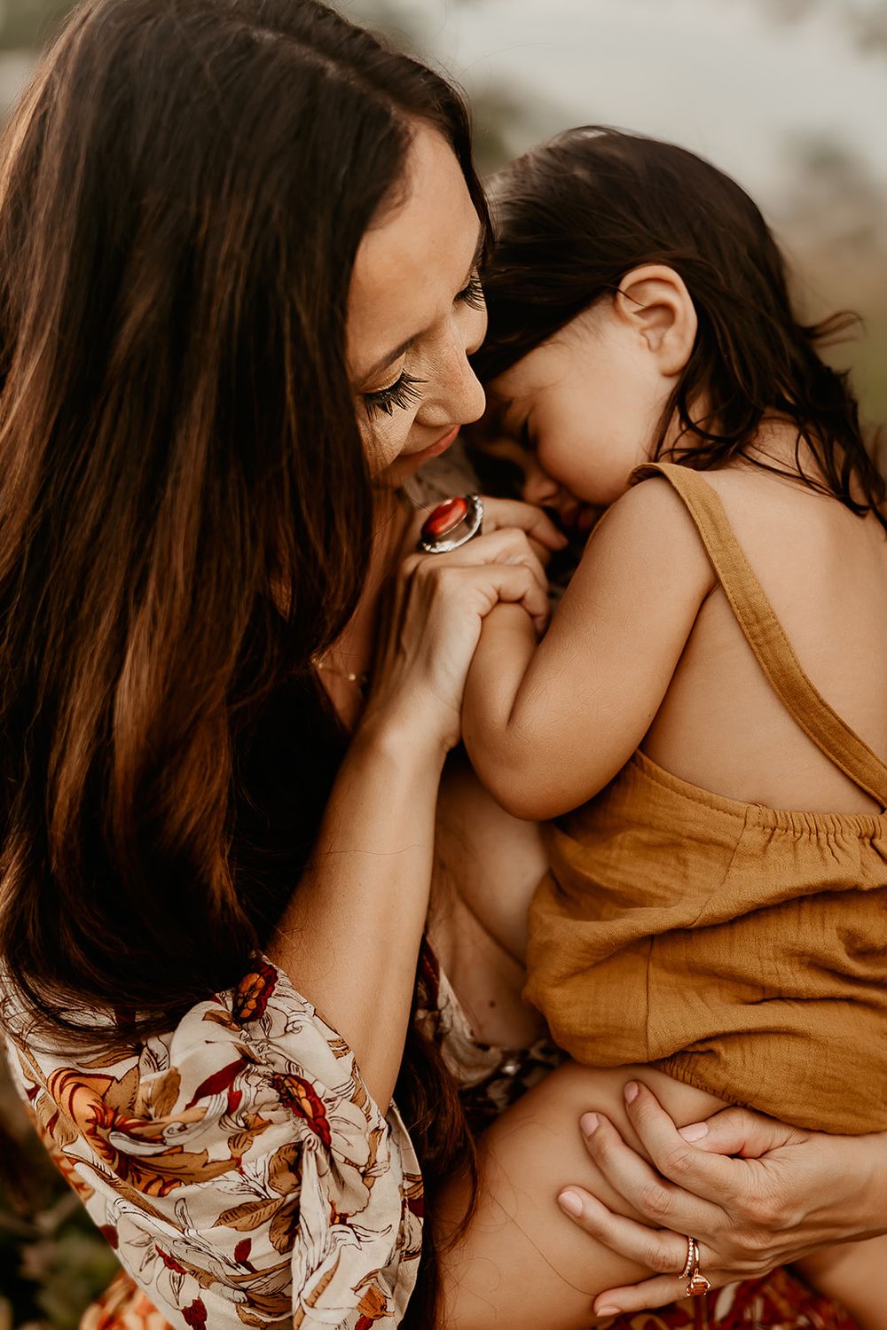 A little girl lays on her mother's chest.