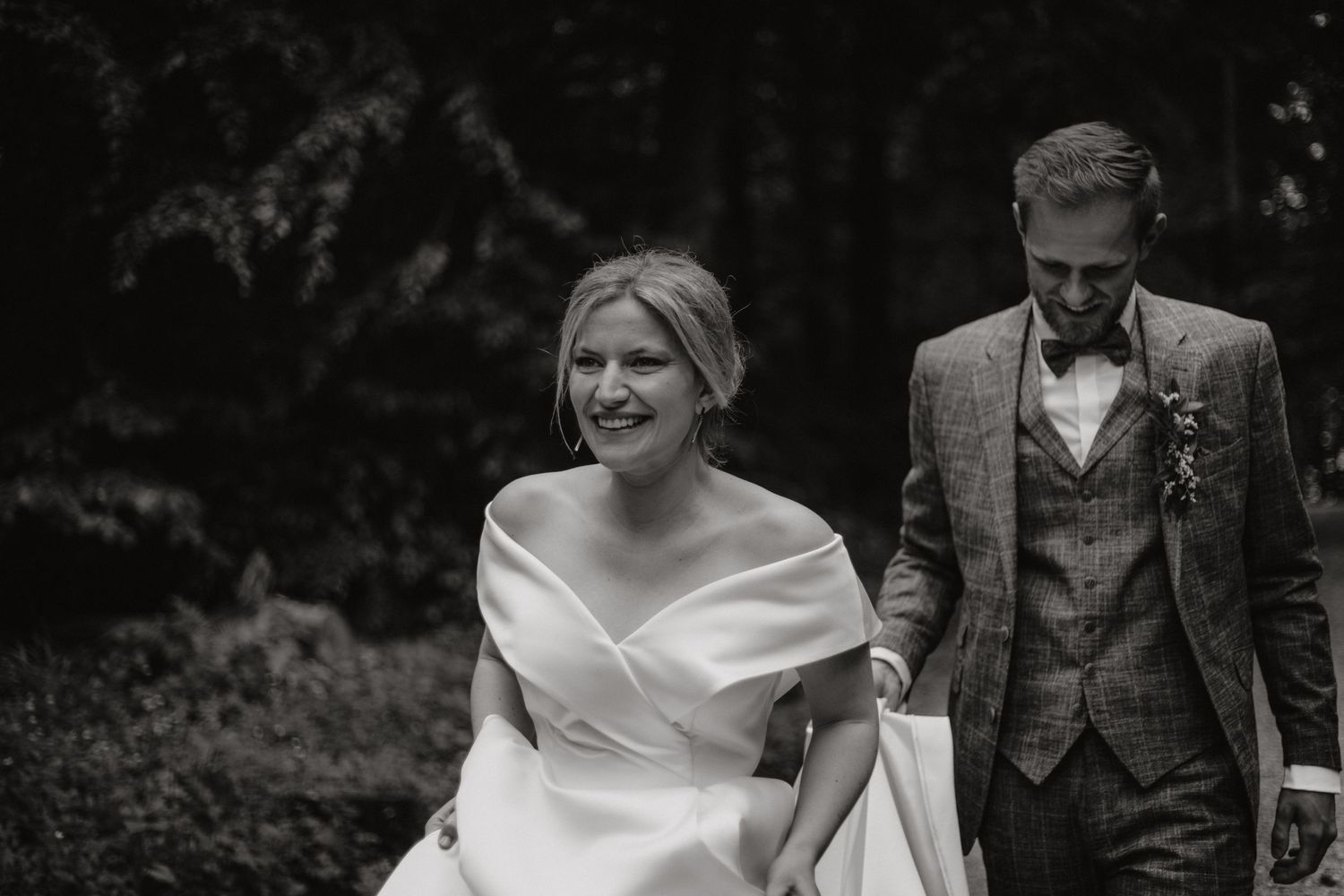 Artistic black and white wedding photography in a wooded setting.