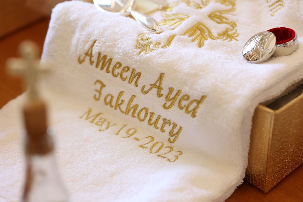Close-up of embroidered baptism towel with gold lettering and details.