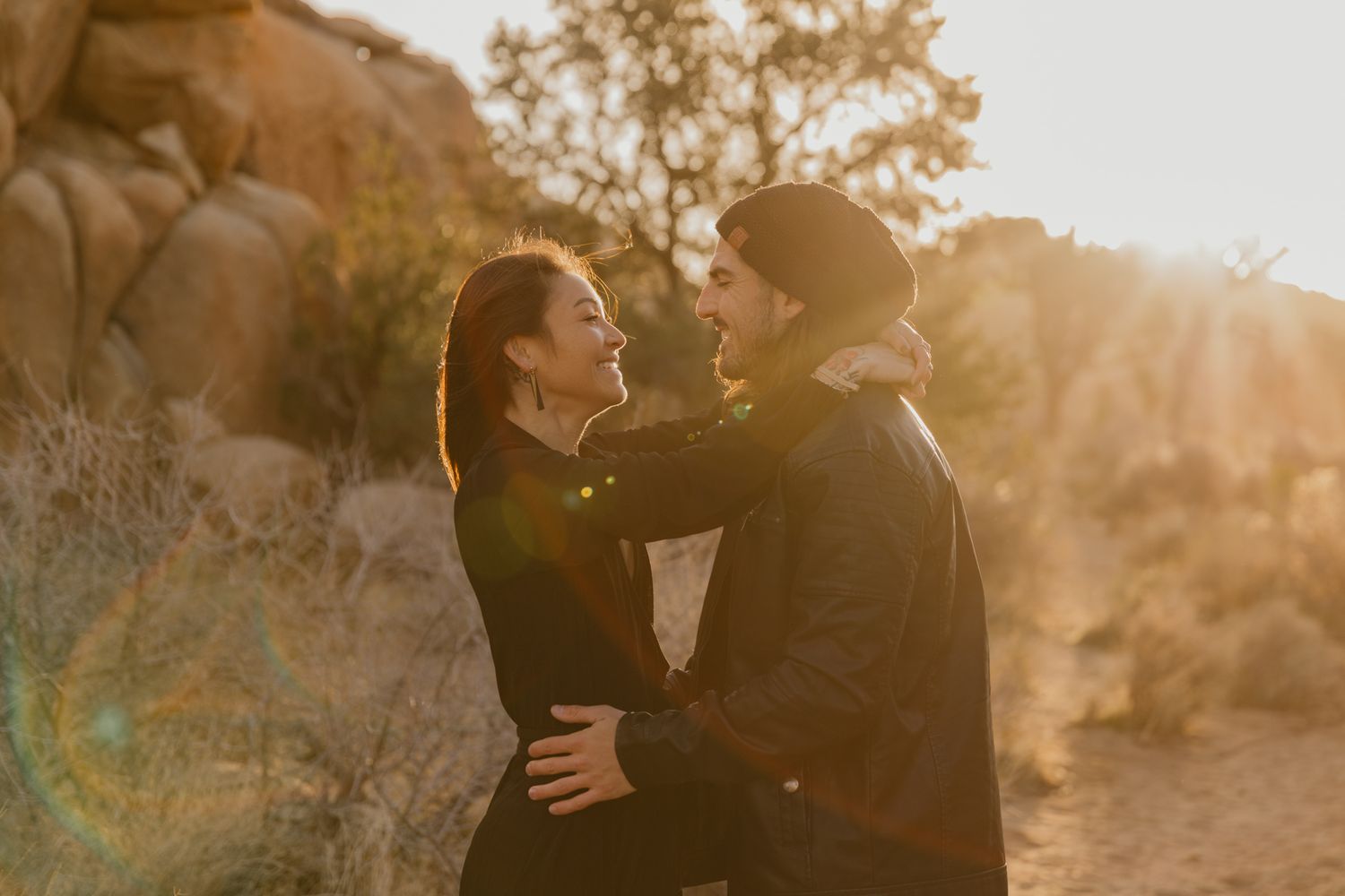 A couple shares intimate moments in Joshua Tree, California during golden hour sunset lighting.