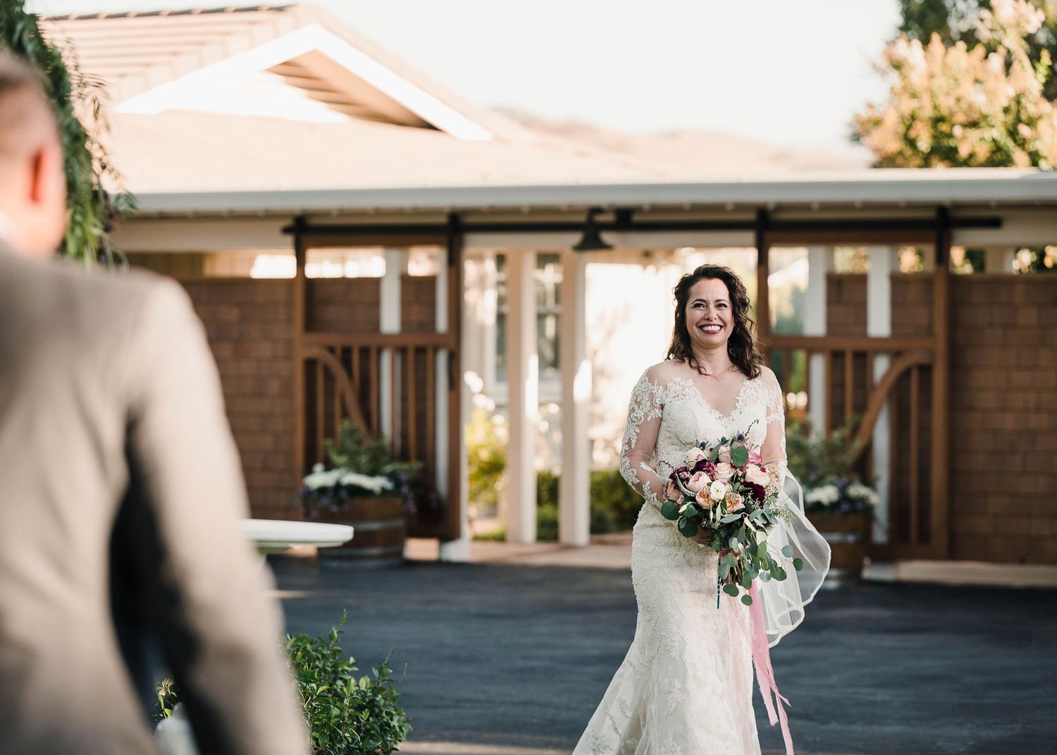 A joyful wedding moment captured outside a brick venue with beautiful natural lighting.