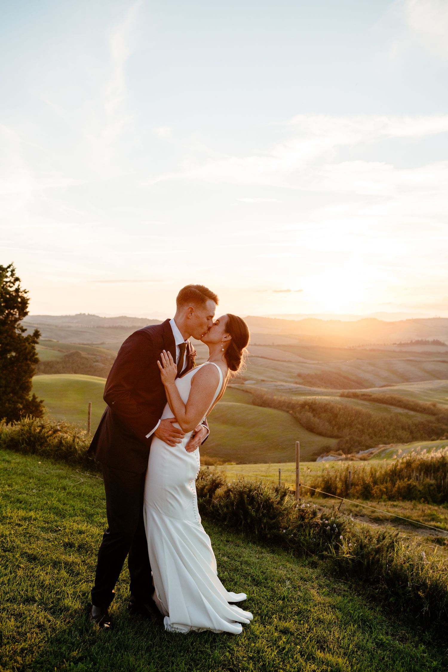 A kiss between a wedding couple as the sun sets at The Lazy Olive near Asciano.