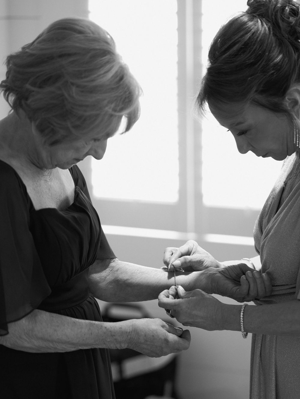 Close-up shot of hands preparing or adjusting something by a window.