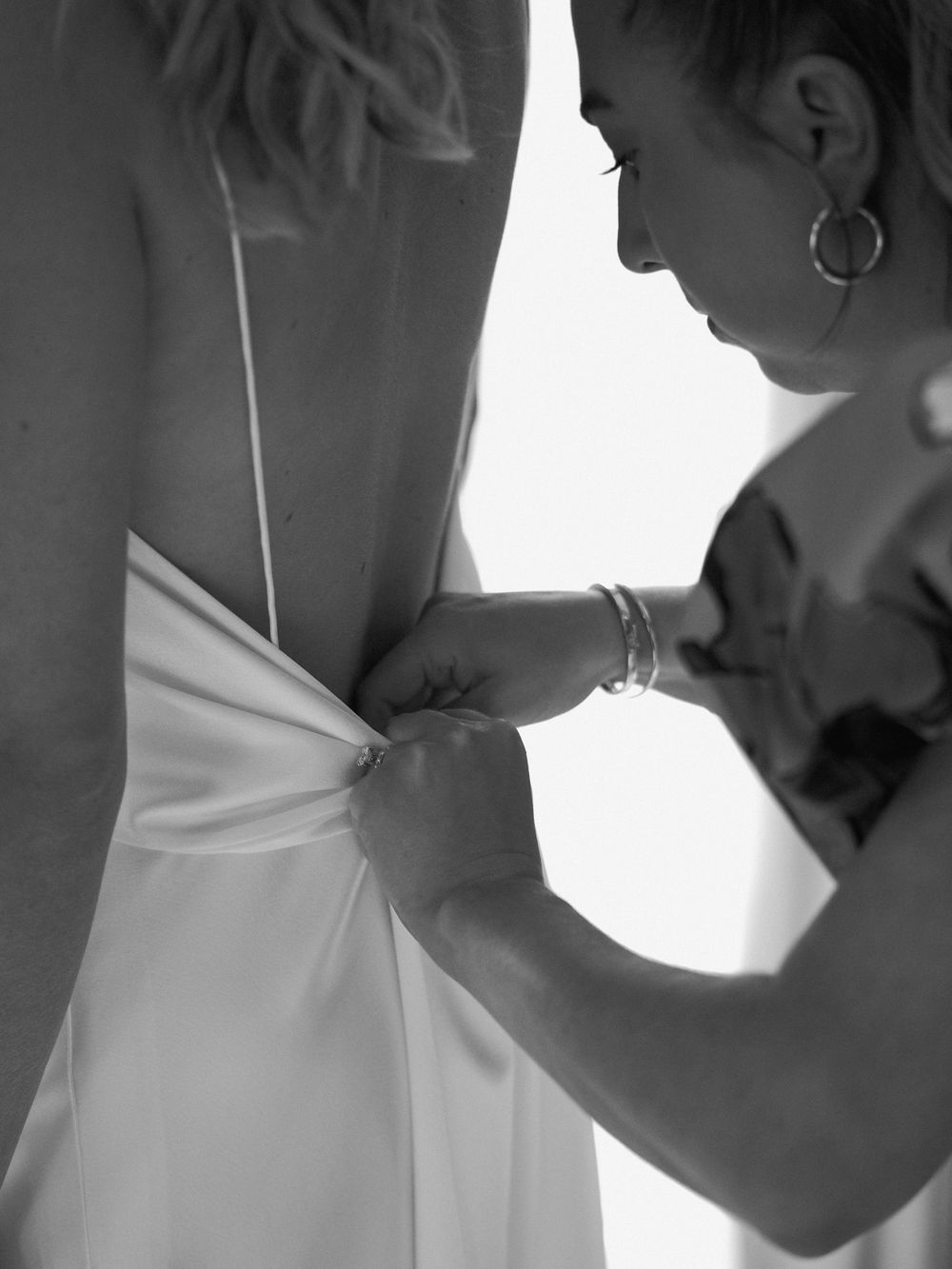 Close-up black and white photo of dress preparation with careful attention to detail.