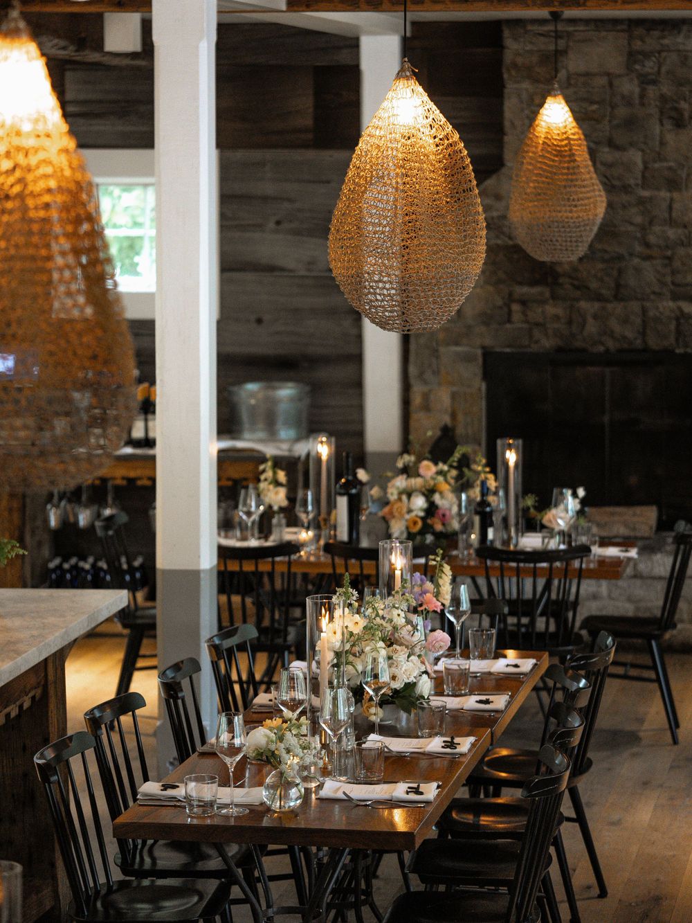 Restaurant dining room with unique teardrop-shaped pendant lights and rustic table settings.