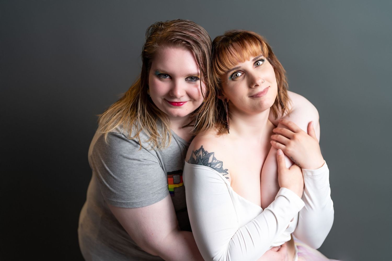 Studio portrait session with soft lighting against dark grey background.