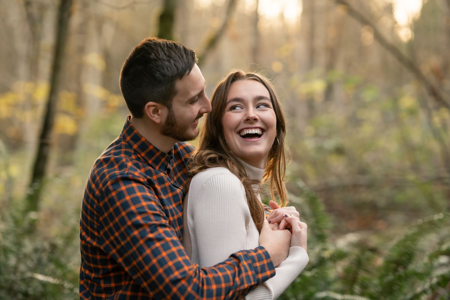 Romantic autumn engagement photos captured in a wooded setting with soft natural light.