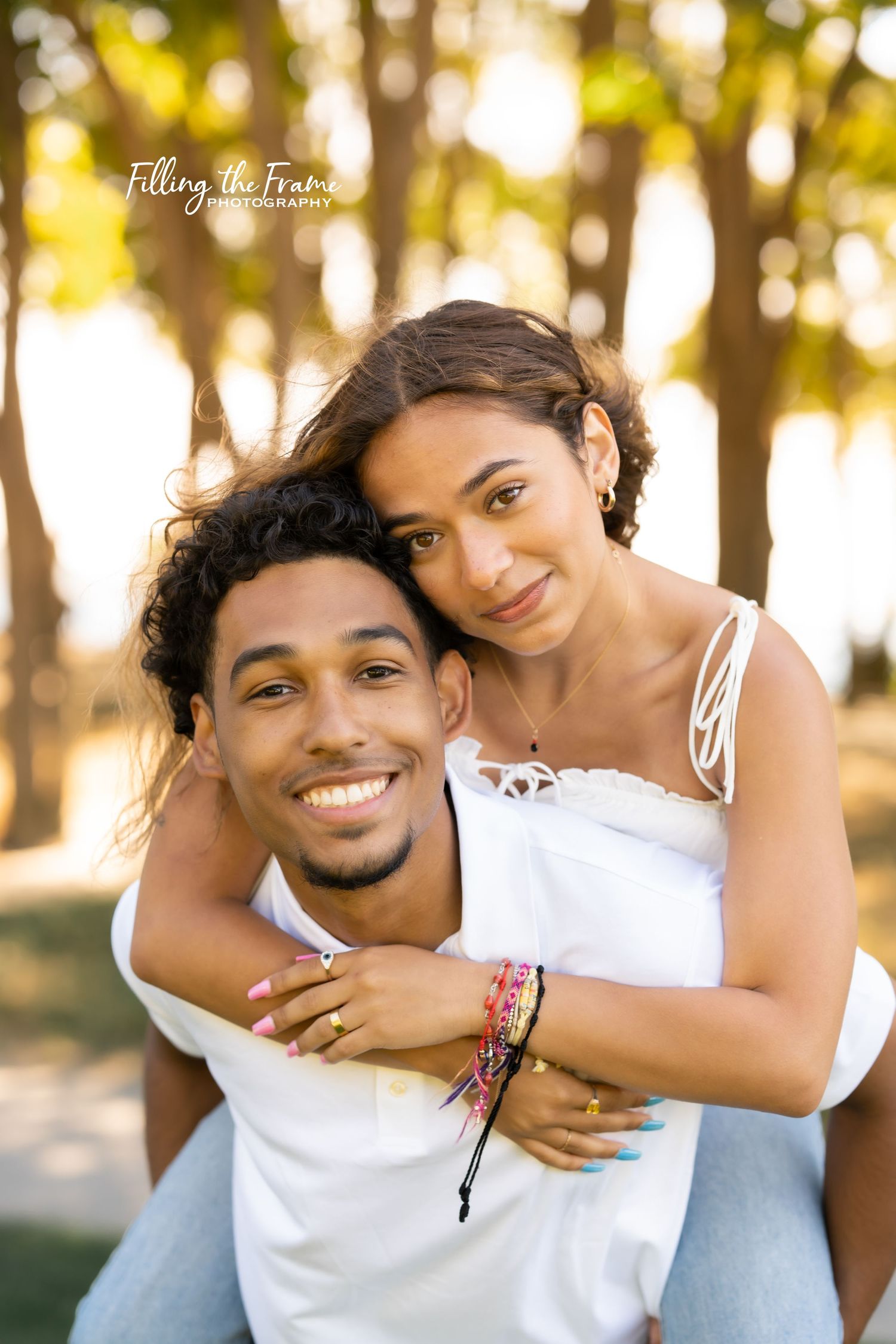 Joyful summer couple photoshoot with golden sunset lighting in a wooded setting.