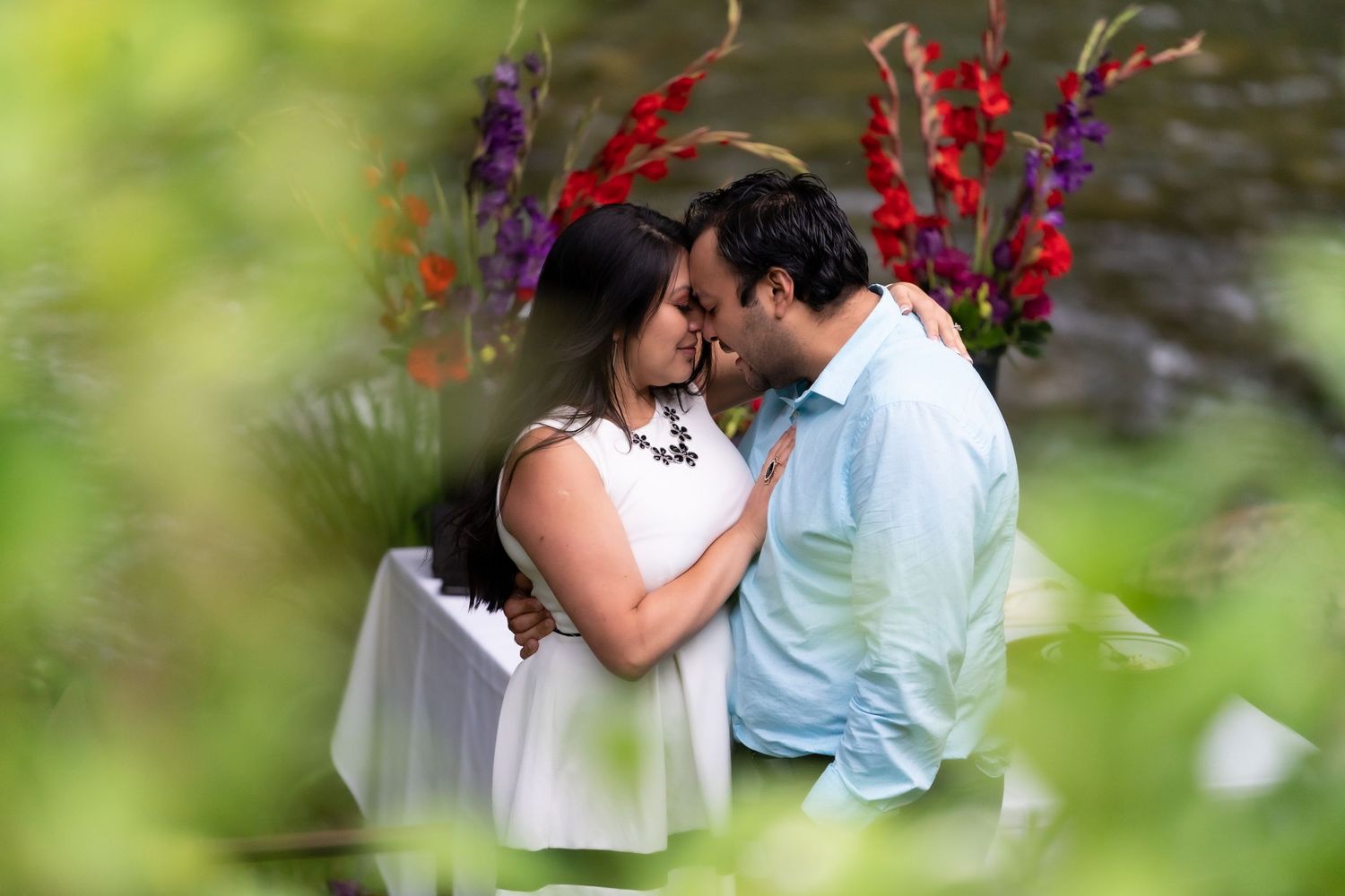 Garden photoshoot with vibrant red and purple flowers in soft focus.