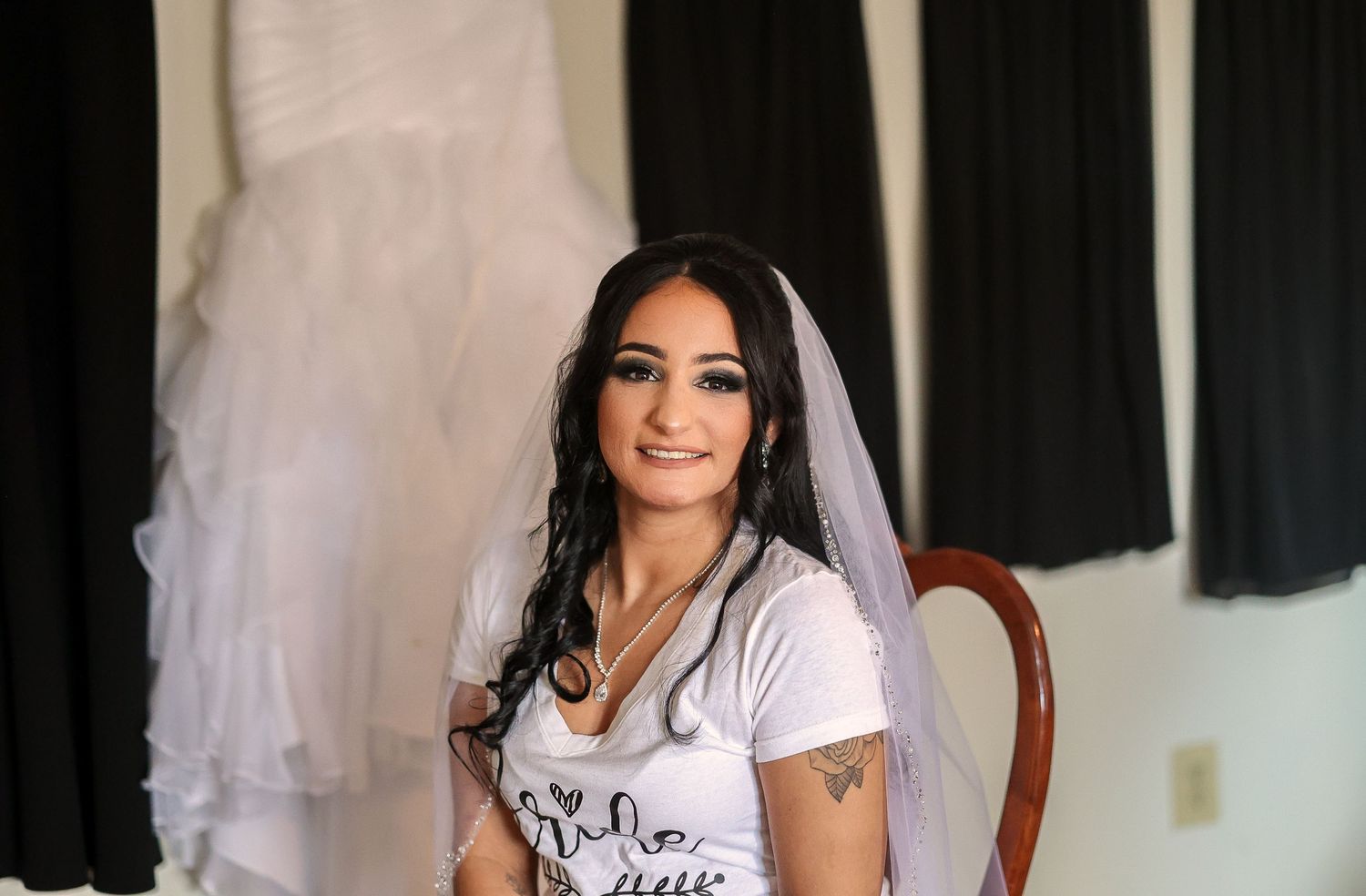 Elegant bridal preparation scene with white veil and dark interior backdrop.
