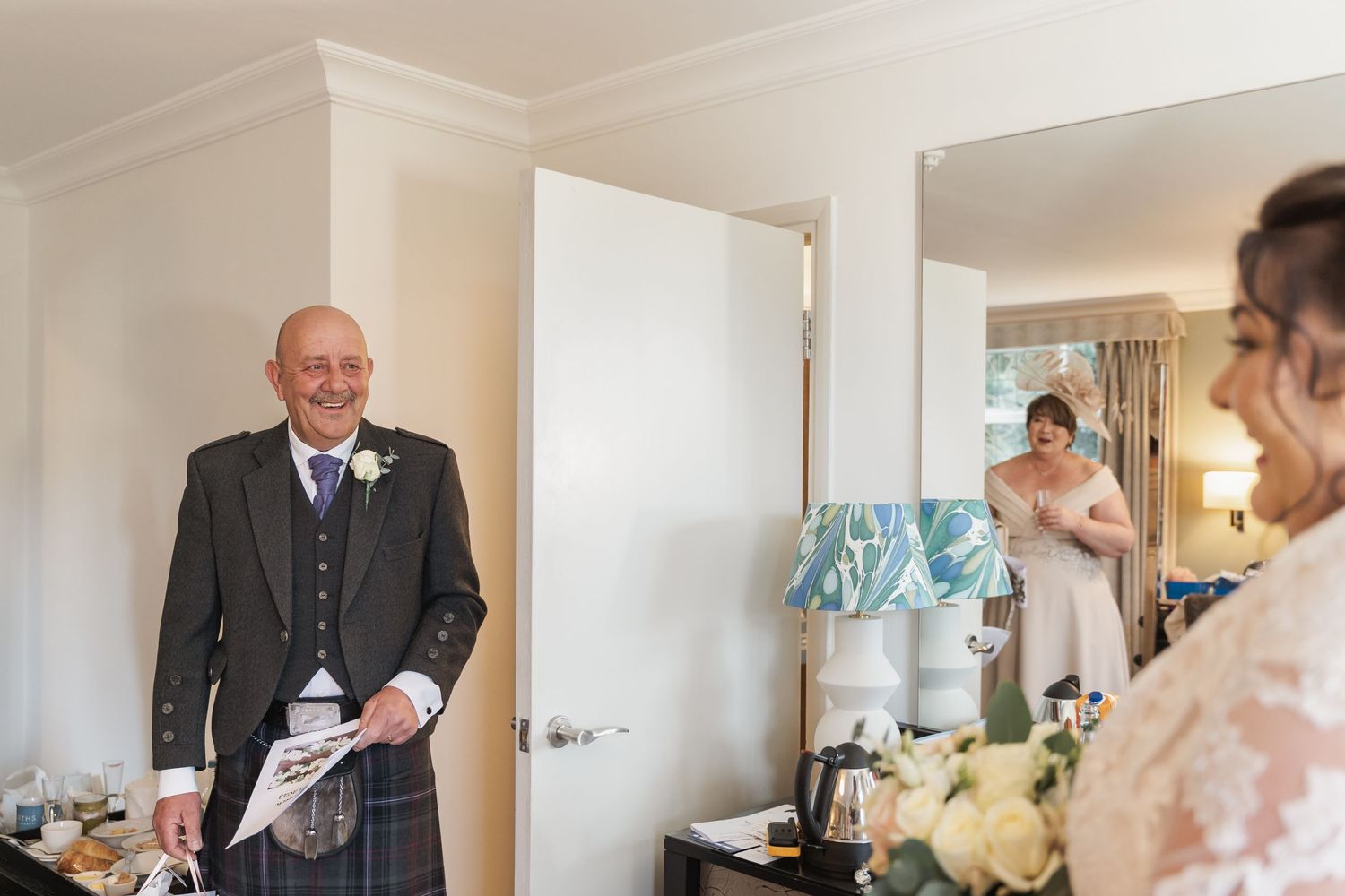 Wedding preparation scene in bright white room with formal attire.