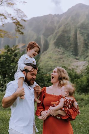 A candid family photo capturing pure joy and laughter with mountains in the background.