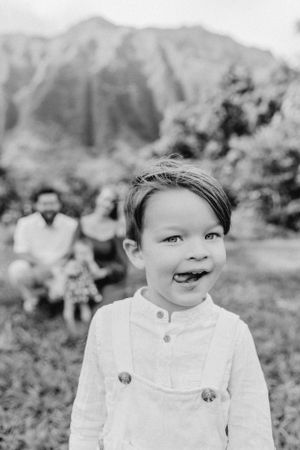 A black and white portrait showcasing pure joy with mountains in the background.