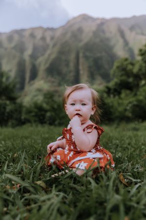 A family enjoying a playful moment together in front of dramatic mountain scenery.