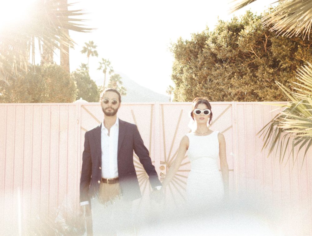 retro palm springs couple stand at Trixie motel for their elopement photos in palm springs