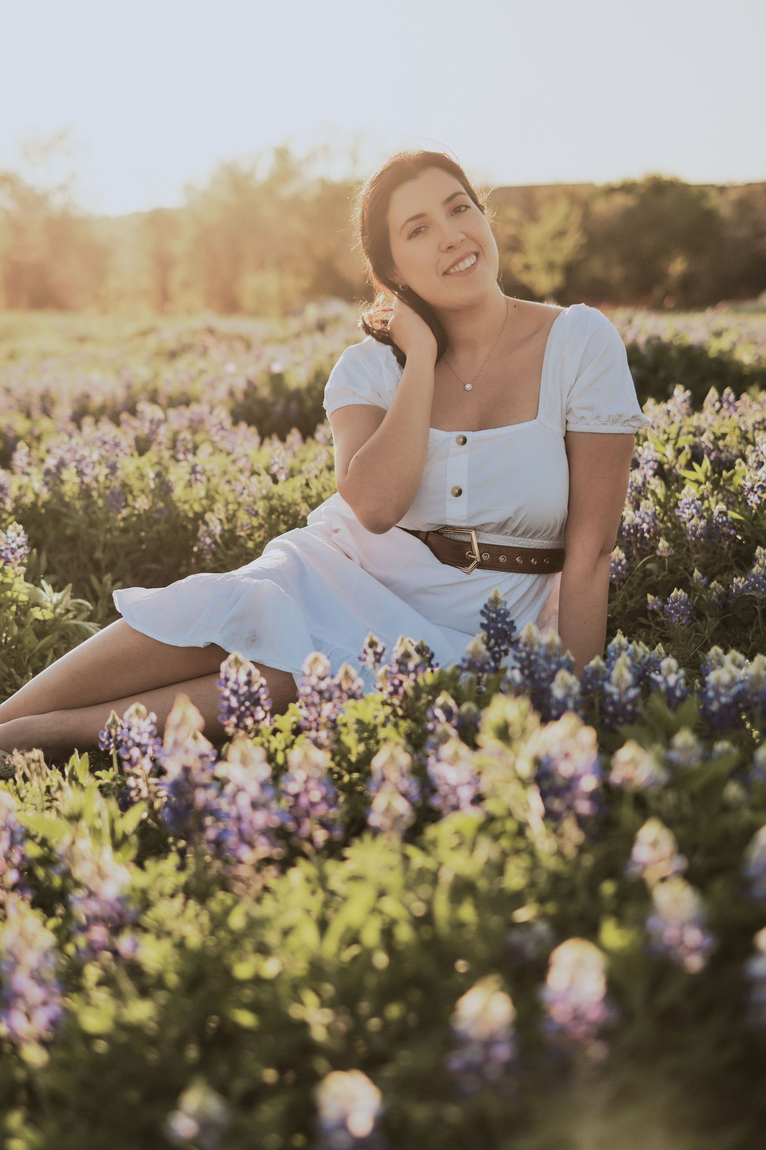 White sundress and wildflowers in golden sunset meadow.