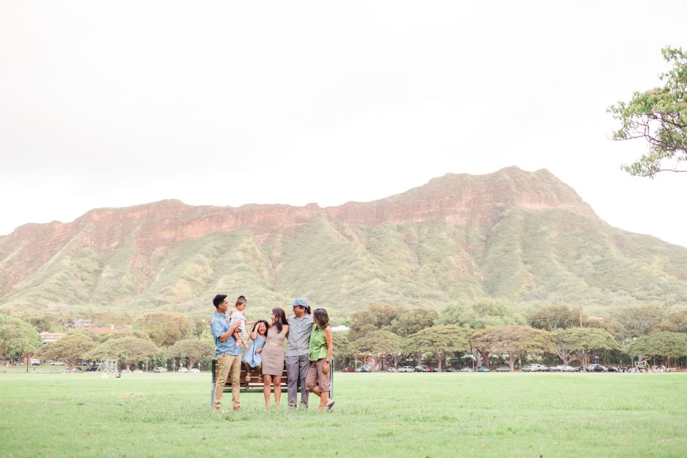 A group stands together in a grassy field with Diamond Head crater visible in the background.