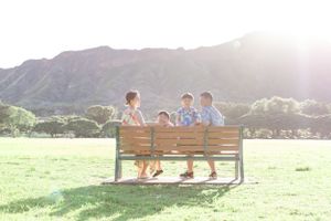 People relaxing on a wooden bench in a scenic mountain park during golden hour.