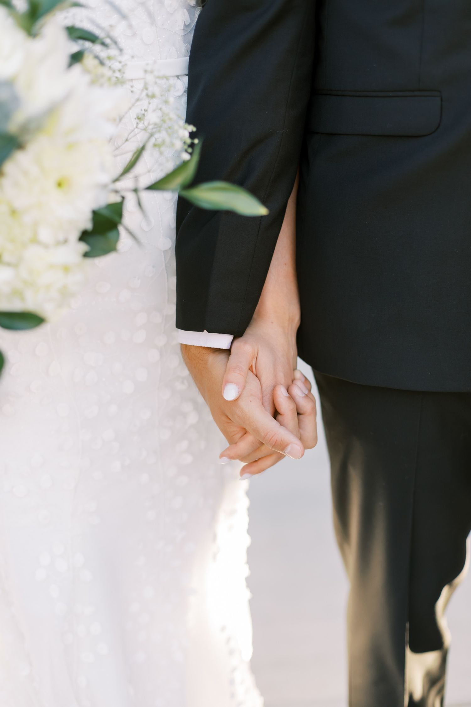 close up of bride and groom holding hands at provo city center temple grounds