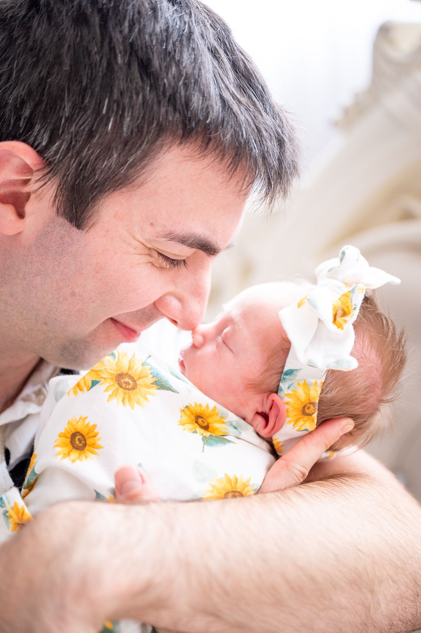 Dad nose kissing his newborn daughter