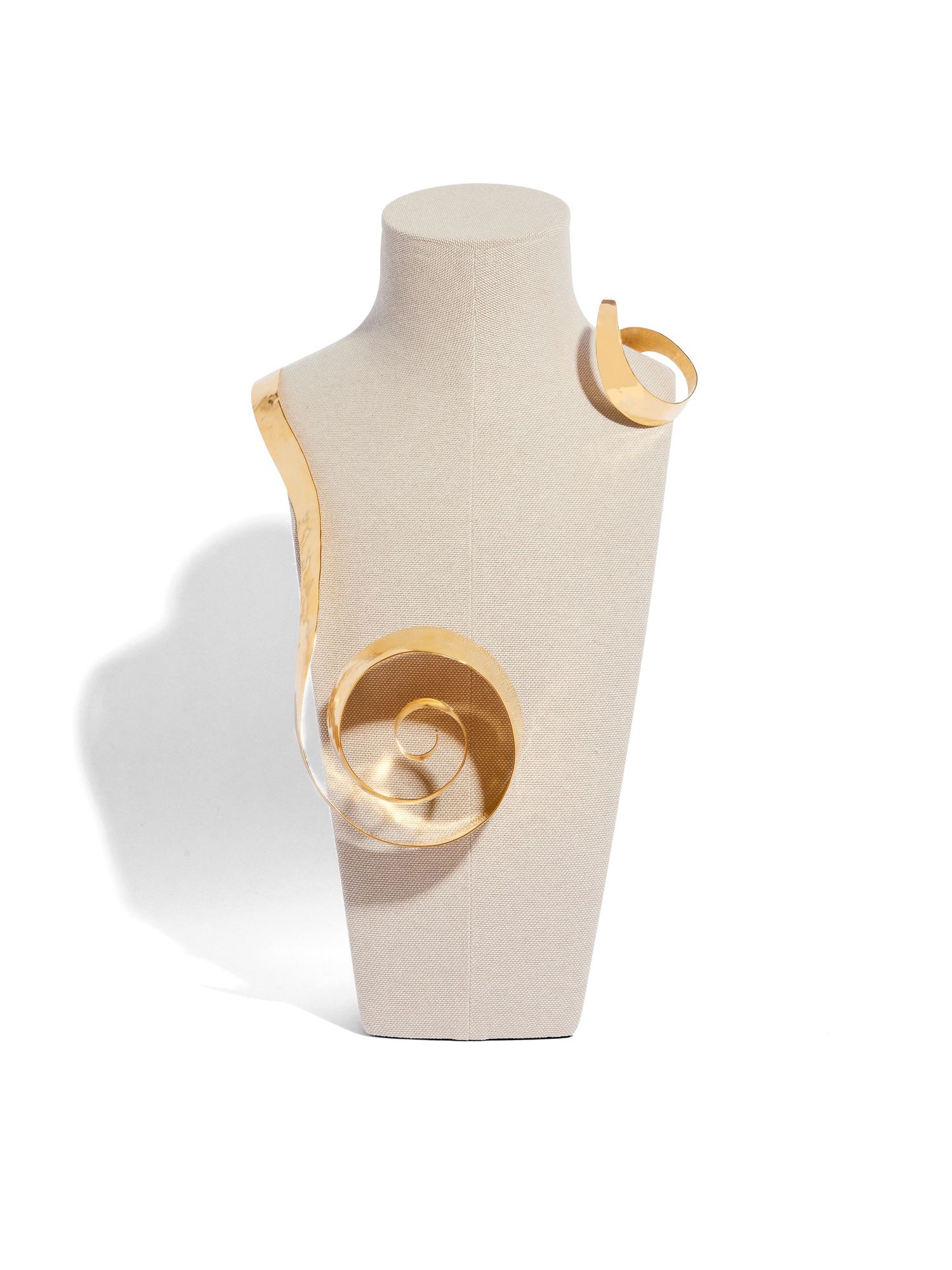Modern abstract gold necklace with curved geometric shapes on display bust.